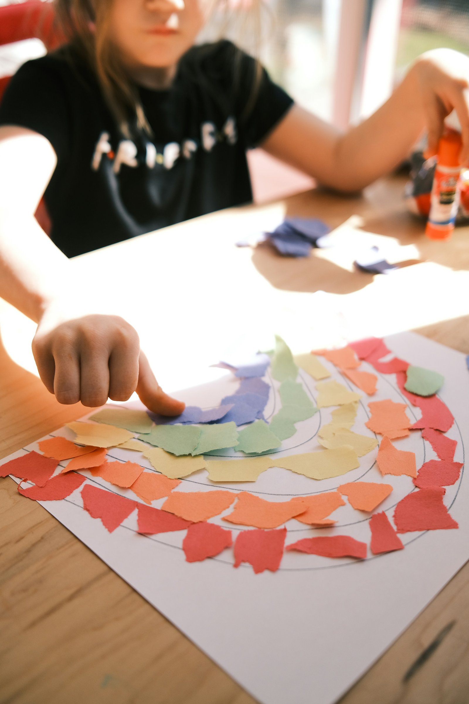 A Wild Pear student creating art with torn paper